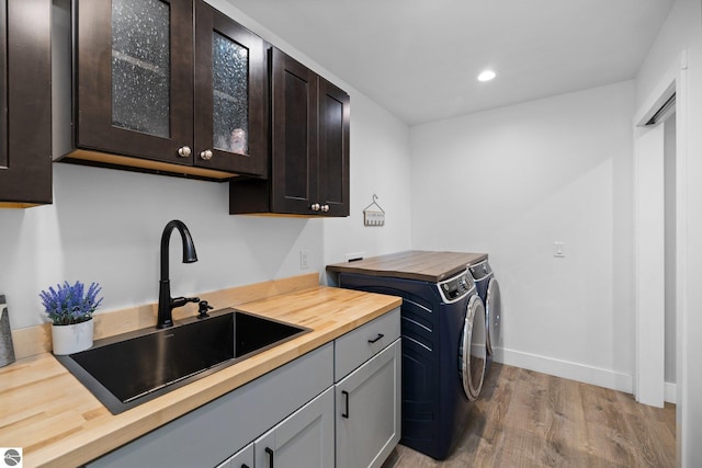 6330 Lund Rd SW, Fife Lake, MI 49633 - laundry area featuring washer and dryer, cabinet space, light wood finished floors, and recessed lighting