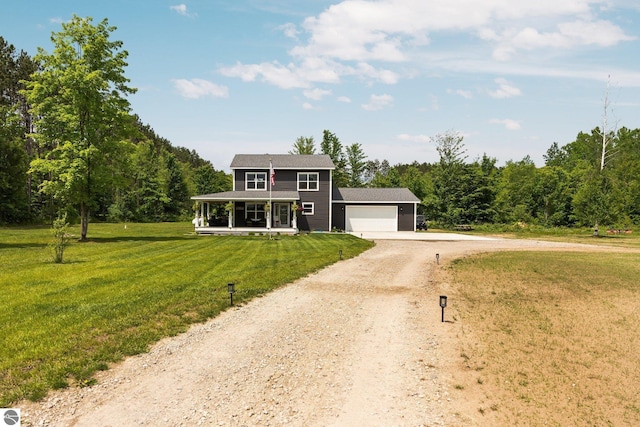 6330 Lund Rd SW, Fife Lake, MI 49633 - view of front of property with driveway, covered porch, an attached garage, a front lawn, and a forest view