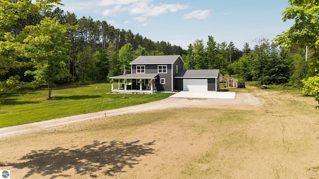 6330 Lund Rd SW, Fife Lake, MI 49633 - view of front of house featuring driveway, a porch, an attached garage, a front yard, and a wooded view