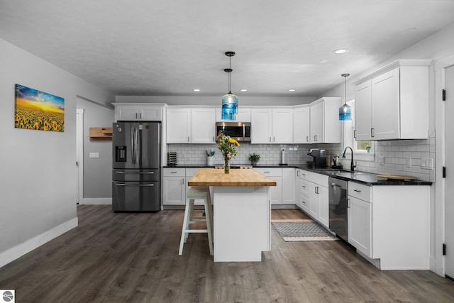 6330 Lund Rd SW, Fife Lake, MI 49633 - kitchen with appliances with stainless steel finishes, butcher block counters, backsplash, a kitchen island, and white cabinetry