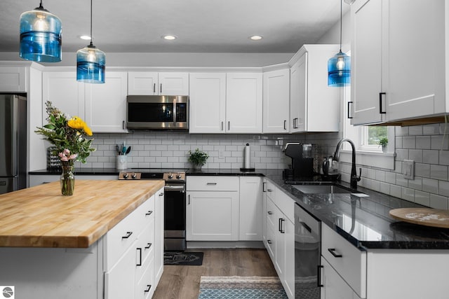 6330 Lund Rd SW, Fife Lake, MI 49633 - kitchen featuring appliances with stainless steel finishes, butcher block counters, wood finished floors, white cabinetry, and recessed lighting