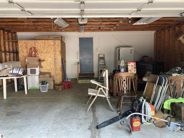 653 S Morrison Rd, West Branch, MI 48661 - garage with freestanding refrigerator and a garage door opener