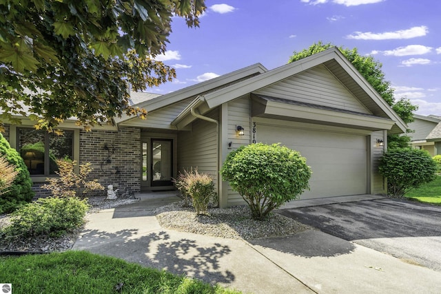 3810 Ridgeway Pl, Traverse City, MI 49684 - ranch-style home featuring a garage, asphalt driveway, and brick siding