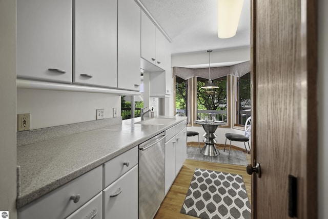 3810 Ridgeway Pl, Traverse City, MI 49684 - kitchen with dishwasher, light wood-type flooring, white cabinets, and light countertops