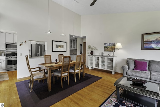 3810 Ridgeway Pl, Traverse City, MI 49684 - dining area featuring light wood-style floors, a high ceiling, and ceiling fan