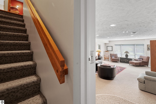 3810 Ridgeway Pl, Traverse City, MI 49684 - stairway featuring carpet, a textured ceiling, and recessed lighting