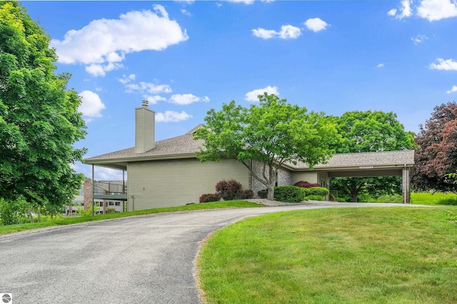 3810 Ridgeway Pl, Traverse City, MI 49684 - view of front of property featuring driveway, a front yard, and a chimney