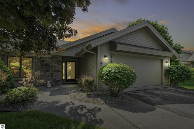 3810 Ridgeway Pl, Traverse City, MI 49684 - ranch-style home featuring driveway, an attached garage, and brick siding