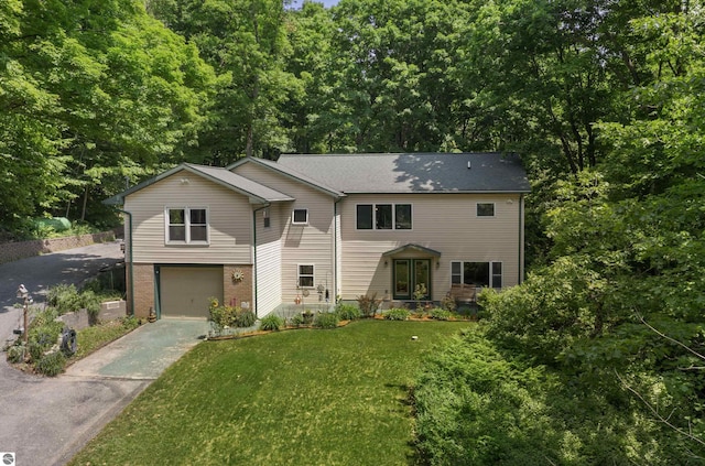 3048 Frankfort Hwy, Frankfort, MI 49635 - view of front of home featuring driveway, a garage, and a front lawn