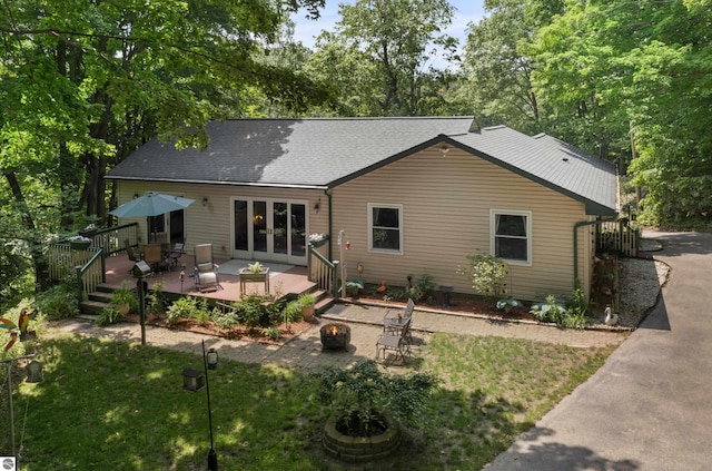 3048 Frankfort Hwy, Frankfort, MI 49635 - rear view of house featuring an outdoor fire pit, a deck, french doors, and a yard