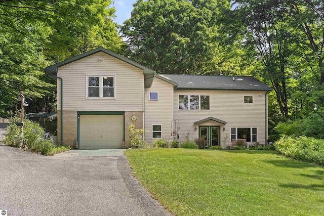 3048 Frankfort Hwy, Frankfort, MI 49635 - view of front of home featuring asphalt driveway, a front lawn, a garage, and brick siding