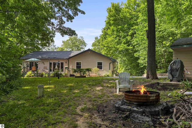 3048 Frankfort Hwy, Frankfort, MI 49635 - back of property with an outdoor fire pit and a lawn