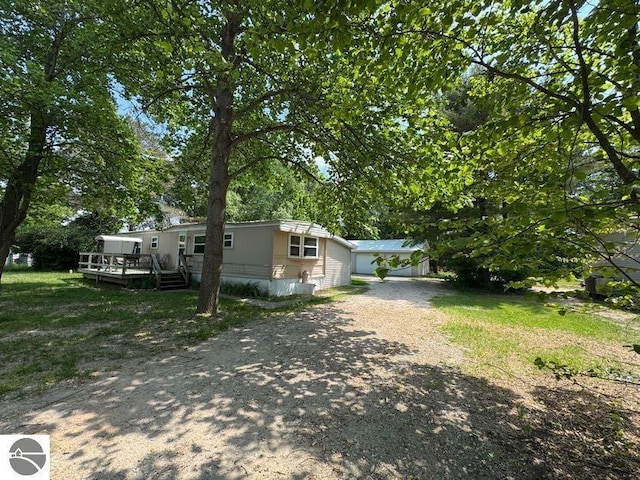 126 Chippewa Trl, Buckley, MI 49620 - view of home's exterior with a wooden deck, driveway, and view of scattered trees