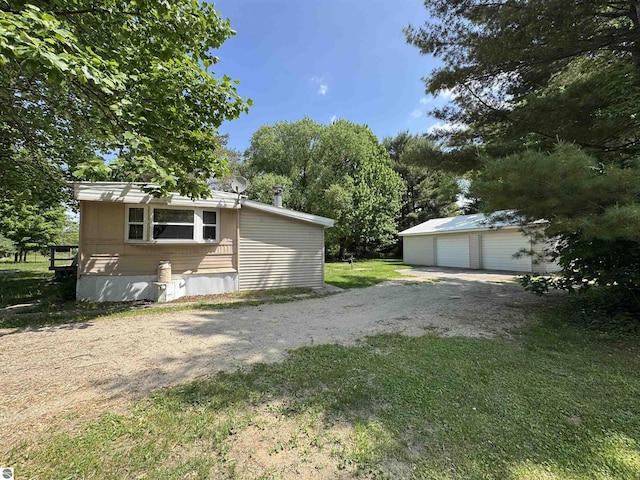 126 Chippewa Trl, Buckley, MI 49620 - view of front of home with an outdoor structure, a detached garage, and a front yard