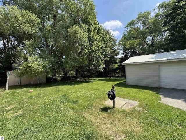 126 Chippewa Trl, Buckley, MI 49620 - view of green lawn with a storage unit and a garage