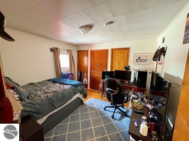 180 S Benzie Blvd, Beulah, MI 49617 - bedroom featuring wood finished floors and a desk