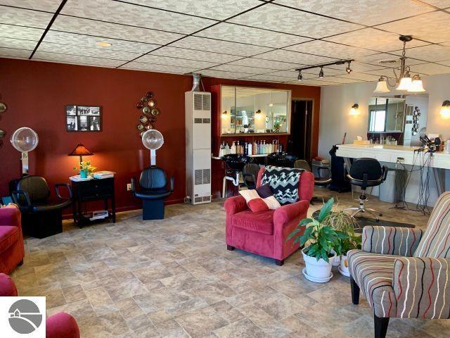 180 S Benzie Blvd, Beulah, MI 49617 - living room featuring a heating unit, rail lighting, and stone finish floors