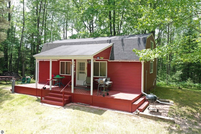5218 E Laird Lake Rd, Hale, MI 48739 - view of front of property featuring roof with shingles, a gambrel roof, a front yard, and a wooden deck