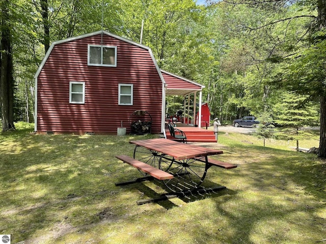 5218 E Laird Lake Rd, Hale, MI 48739 - rear view of house with a gambrel roof, a yard, and a wooded view