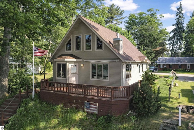 6387 W Maple St, Lake City, MI 49651 - view of front facade featuring a wooden deck, roof with shingles, a chimney, and a front yard