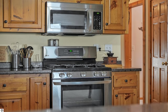 6387 W Maple St, Lake City, MI 49651 - kitchen featuring stainless steel appliances, dark countertops, and brown cabinetry