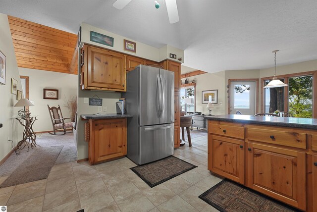 6387 W Maple St, Lake City, MI 49651 - kitchen featuring freestanding refrigerator, dark countertops, brown cabinetry, and a ceiling fan