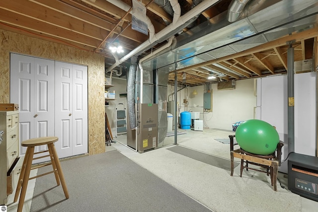 6387 W Maple St, Lake City, MI 49651 - unfinished basement featuring heating unit, a water pressure tank, gas water heater, and electric panel