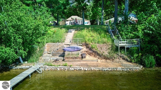 7600 Maple St, Grawn, MI 49637 - view of yard with stairs, a water view, and a dock