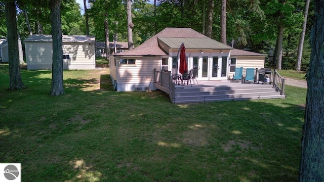 7600 Maple St, Grawn, MI 49637 - rear view of property featuring french doors, a wooden deck, a lawn, and view of wooded area