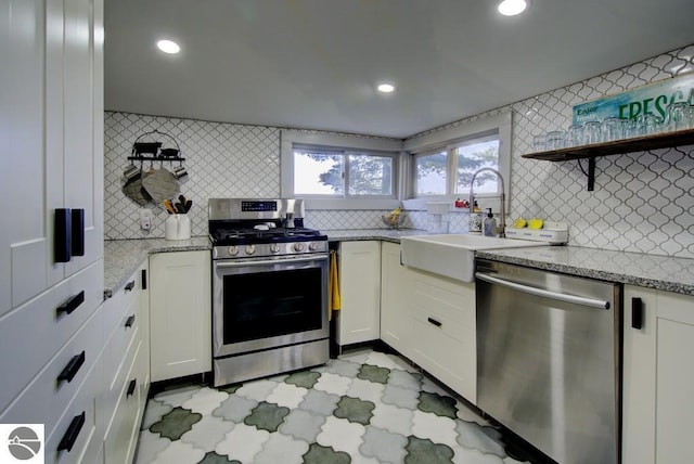 7600 Maple St, Grawn, MI 49637 - kitchen with stainless steel appliances, decorative backsplash, white cabinets, light stone countertops, and recessed lighting