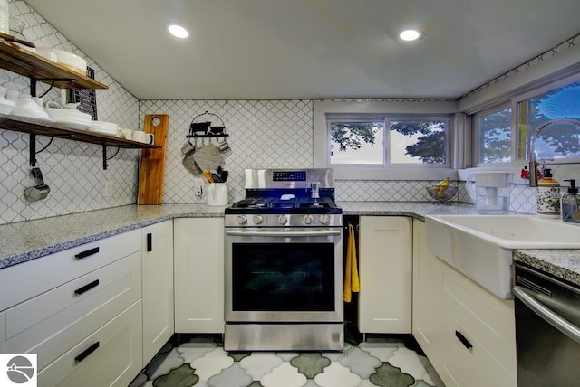 7600 Maple St, Grawn, MI 49637 - kitchen with gas stove, open shelves, dishwashing machine, tasteful backsplash, and white cabinets