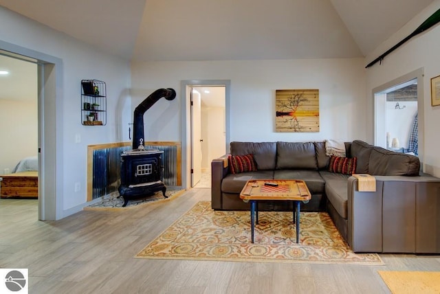 7600 Maple St, Grawn, MI 49637 - living room with lofted ceiling, a wood stove, and wood finished floors