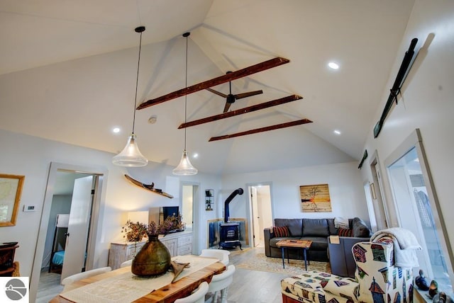 7600 Maple St, Grawn, MI 49637 - living area featuring a wood stove, high vaulted ceiling, light wood-style floors, and beam ceiling