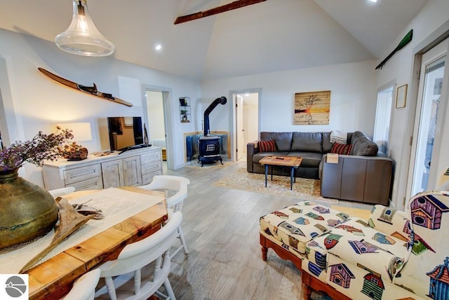 7600 Maple St, Grawn, MI 49637 - living room featuring a wood stove, light wood-type flooring, recessed lighting, and high vaulted ceiling