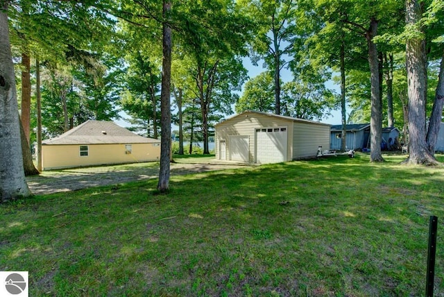 7600 Maple St, Grawn, MI 49637 - view of grassy yard with a garage and an outdoor structure