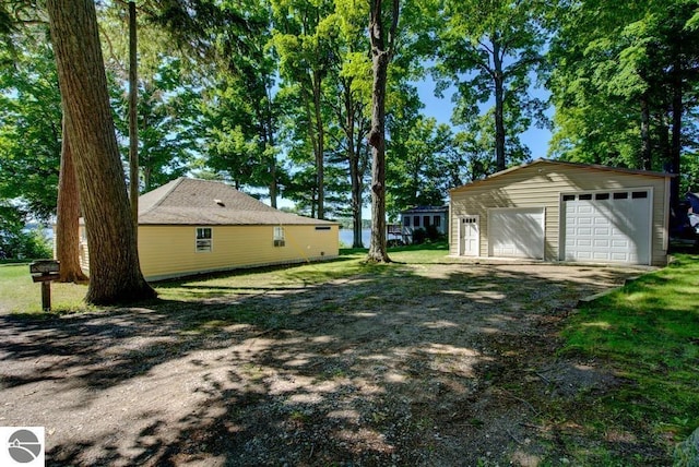 7600 Maple St, Grawn, MI 49637 - view of yard featuring an outdoor structure and a detached garage