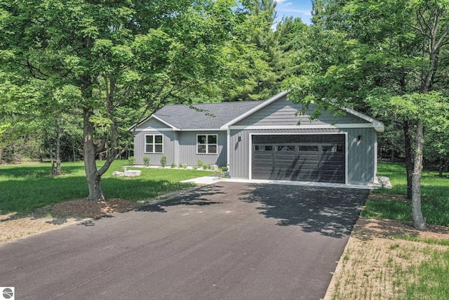6483 Jeffrey Pl, Grawn, MI 49637 - single story home with asphalt driveway, a garage, and a front lawn