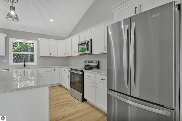 6483 Jeffrey Pl, Grawn, MI 49637 - kitchen featuring stainless steel appliances, lofted ceiling, light wood-style flooring, white cabinetry, and light stone countertops