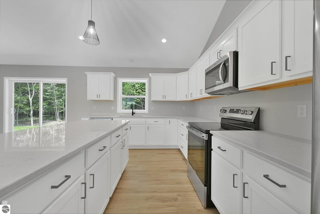 6483 Jeffrey Pl, Grawn, MI 49637 - kitchen with appliances with stainless steel finishes, white cabinetry, light wood-style floors, light stone countertops, and hanging light fixtures