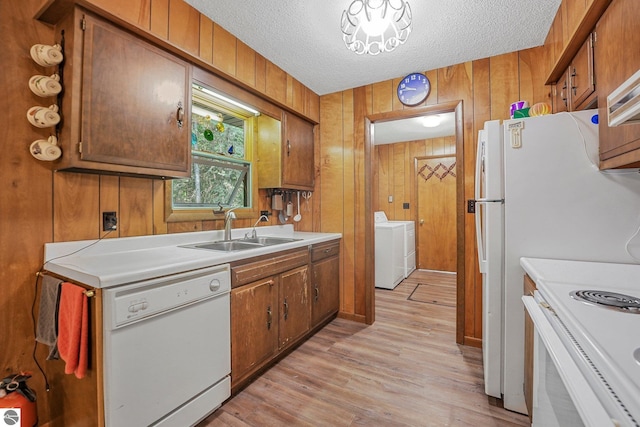 10085 Harmony Dr, Interlochen, MI 49643 - kitchen with white appliances, separate washer and dryer, wood walls, light wood-style flooring, and light countertops