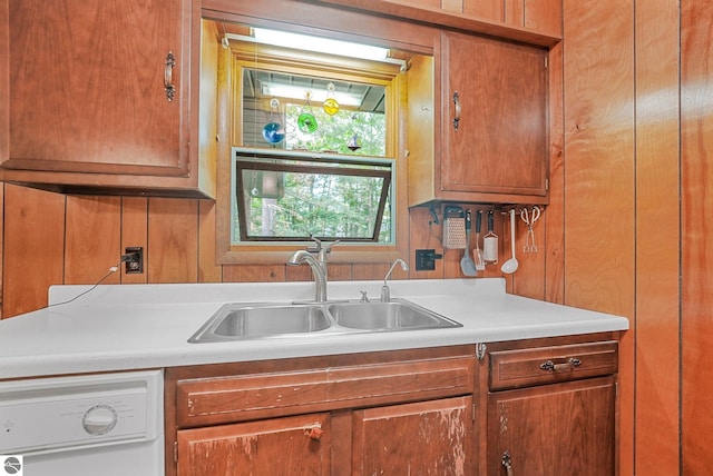 10085 Harmony Dr, Interlochen, MI 49643 - kitchen featuring white dishwasher, light countertops, brown cabinets, and wood walls