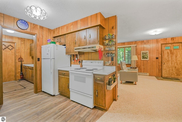 10085 Harmony Dr, Interlochen, MI 49643 - kitchen with white appliances, wood walls, under cabinet range hood, a textured ceiling, and light countertops