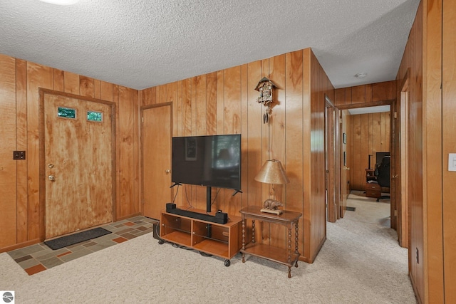 10085 Harmony Dr, Interlochen, MI 49643 - living room with wood walls, a textured ceiling, and carpet floors