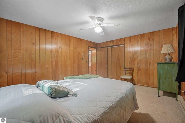 10085 Harmony Dr, Interlochen, MI 49643 - bedroom with wooden walls, carpet, a ceiling fan, and a textured ceiling