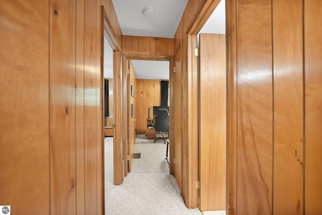 10085 Harmony Dr, Interlochen, MI 49643 - corridor featuring light colored carpet, wooden walls, and a desk