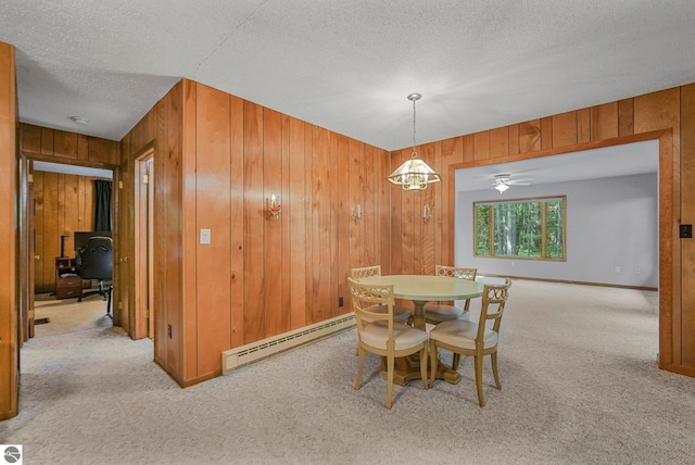 10085 Harmony Dr, Interlochen, MI 49643 - carpeted dining room featuring baseboard heating, wood walls, a textured ceiling, and an office area