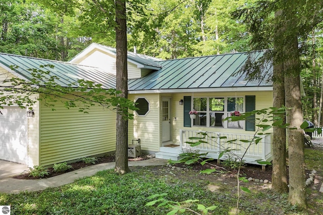 8315 Aimee Ln, Lake Ann, MI 49650 - view of front of home with a standing seam roof, a garage, a metal roof, and covered porch