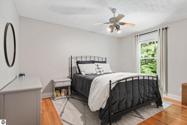 8315 Aimee Ln, Lake Ann, MI 49650 - bedroom featuring light wood-style floors, ceiling fan, and a textured ceiling