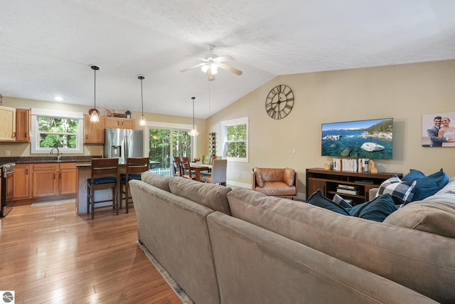 8315 Aimee Ln, Lake Ann, MI 49650 - living room featuring ceiling fan, light wood-style floors, plenty of natural light, and lofted ceiling