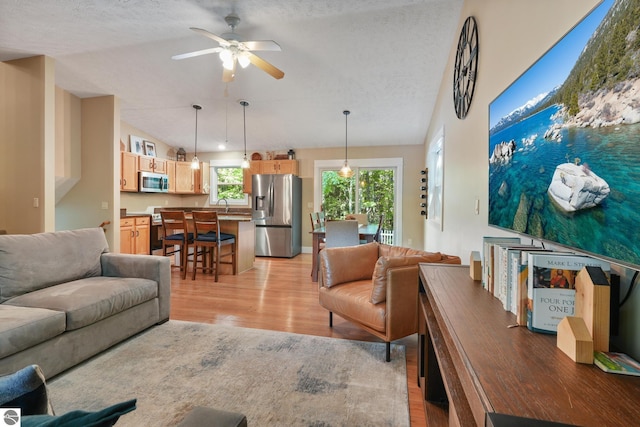 8315 Aimee Ln, Lake Ann, MI 49650 - living area featuring light wood-type flooring, ceiling fan, a textured ceiling, and lofted ceiling